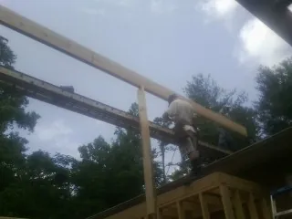 Carpenter setting a ridge beam over a new addition frame — Ice Dam Removal by Roofing Brothers in Pine Bluffs