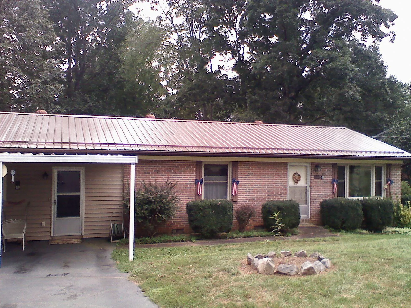 Bronze metal roof and carport on a brick ranch home — Roof Repair work by our crew in Pine Bluffs